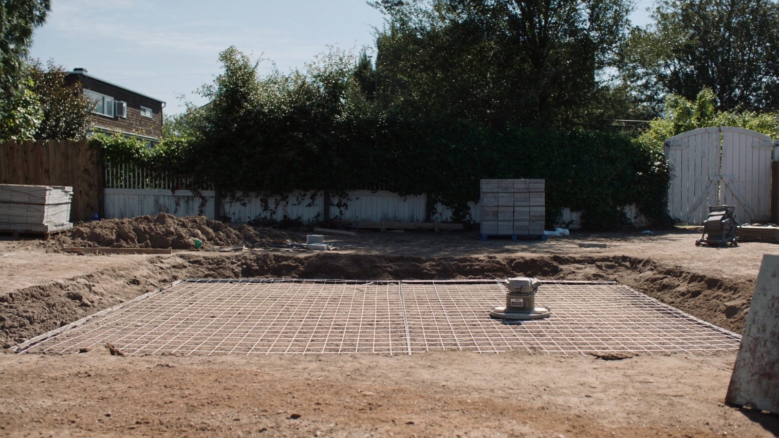 Crushed stone base prep with plate compactor on a Halifax paver patio job site